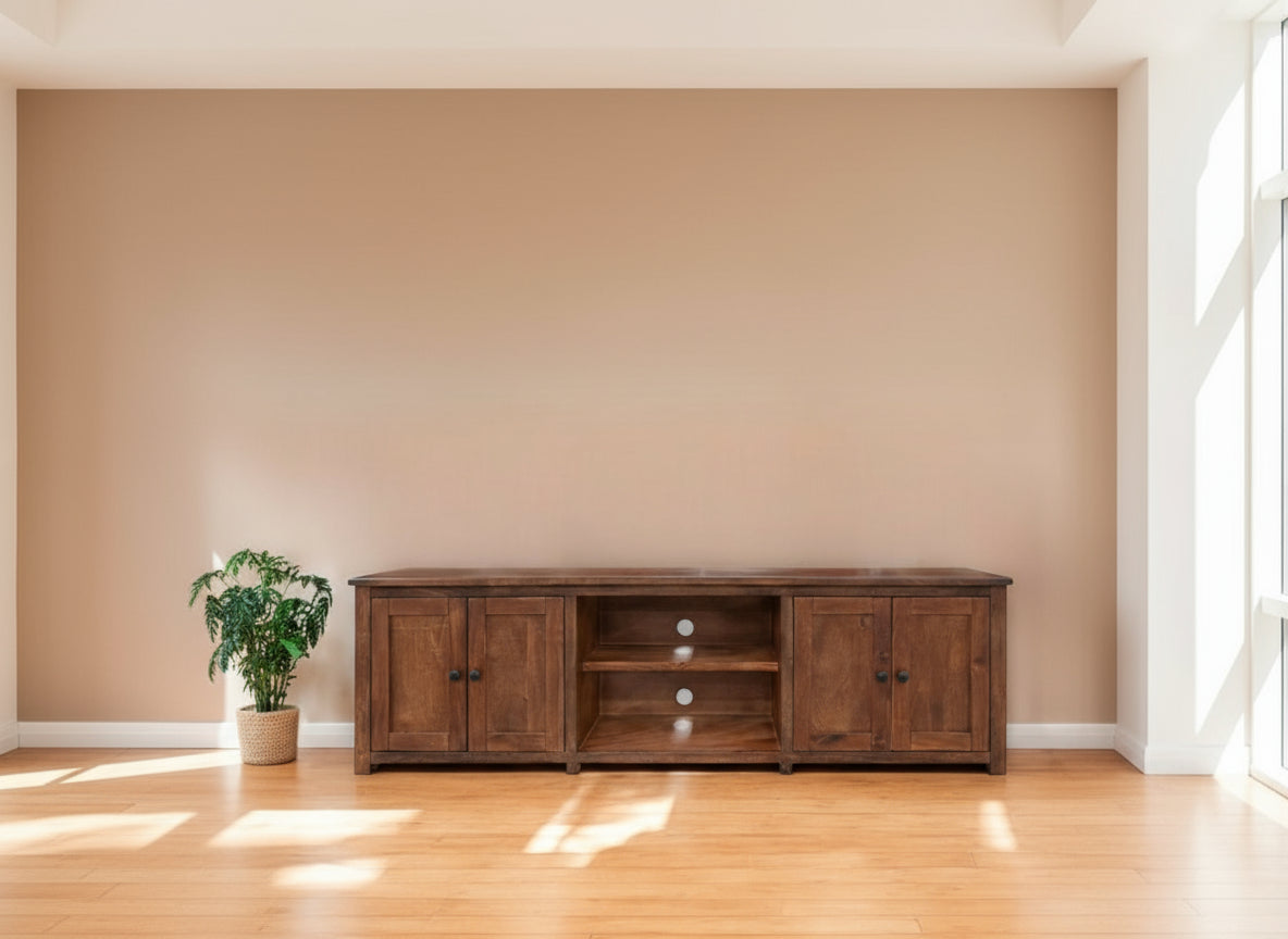 Wooden entertainment console on a wooden floor with a plain wall background