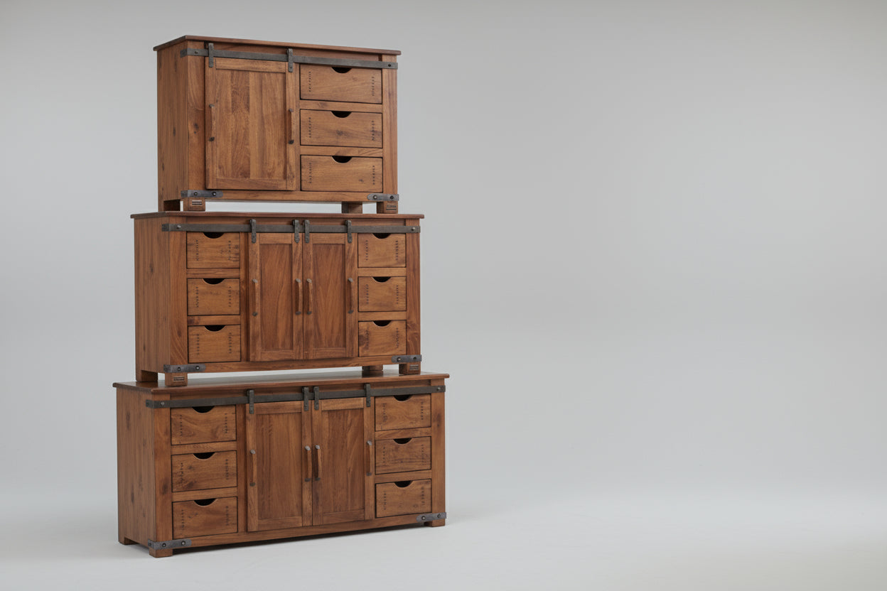 Wooden cabinet with multiple drawers against a textured wall.